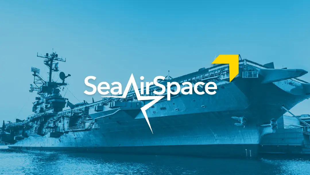 A promotional image for Sea Air Space, featuring the event logo and an aircraft carrier